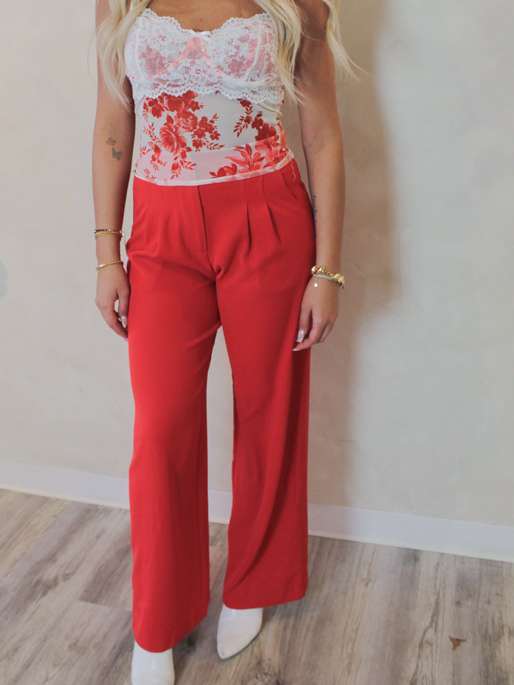 Model wearing a floral mesh tank top and red trouser pants 