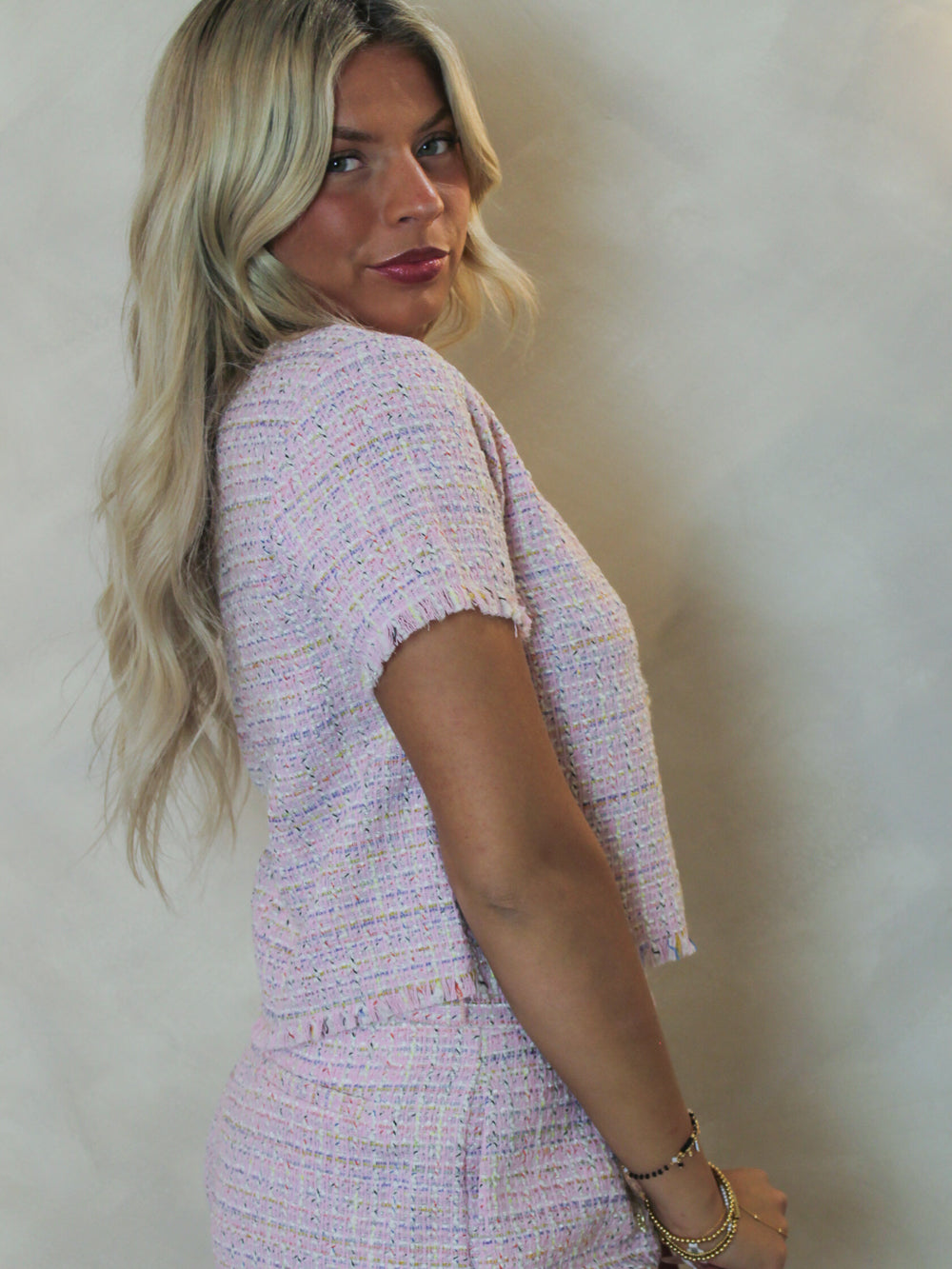 Side view of a pink short sleeve tweed top