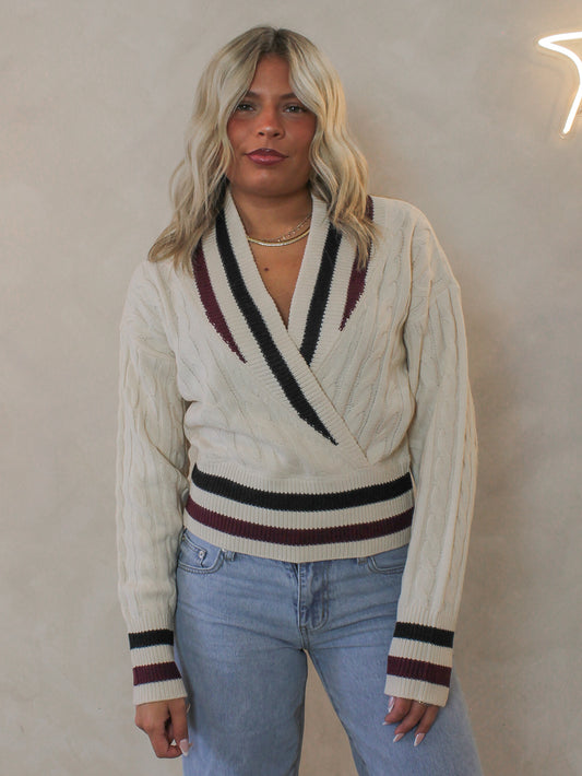 Woman wearing a preppy style, chunky, fall sweater