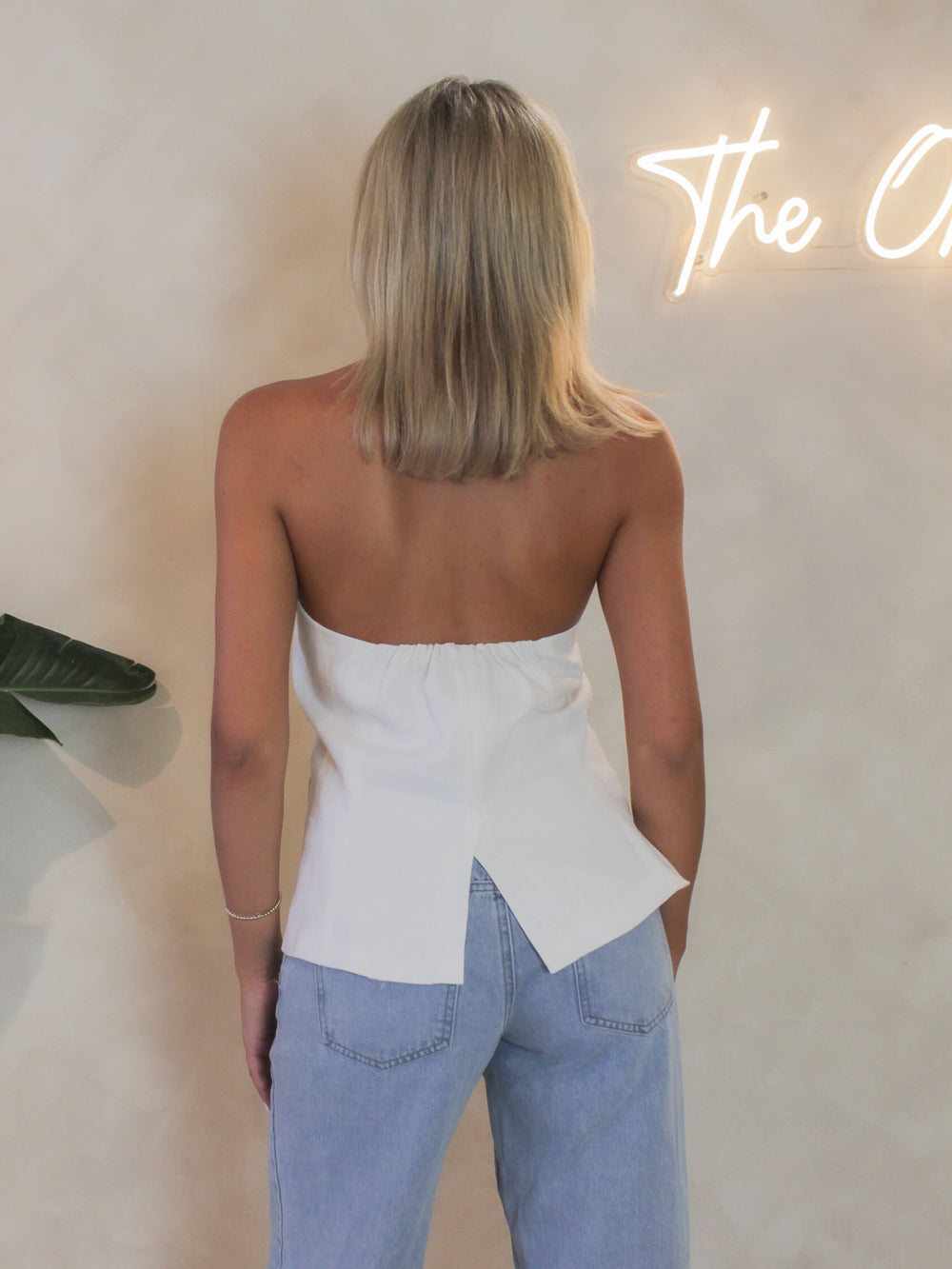 Back view of the white Steve Madden Brielle vest with clean lines  a open back detail