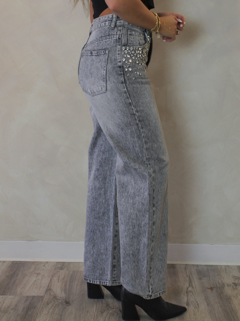 Side view of a model wearing the gray straight leg Eras rhinestone denim 