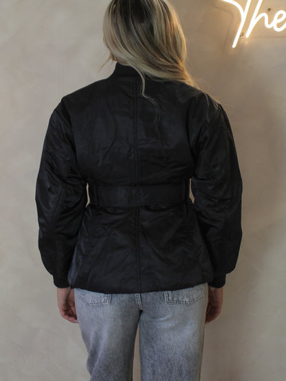 Model wearing a black belted nylon jacket 