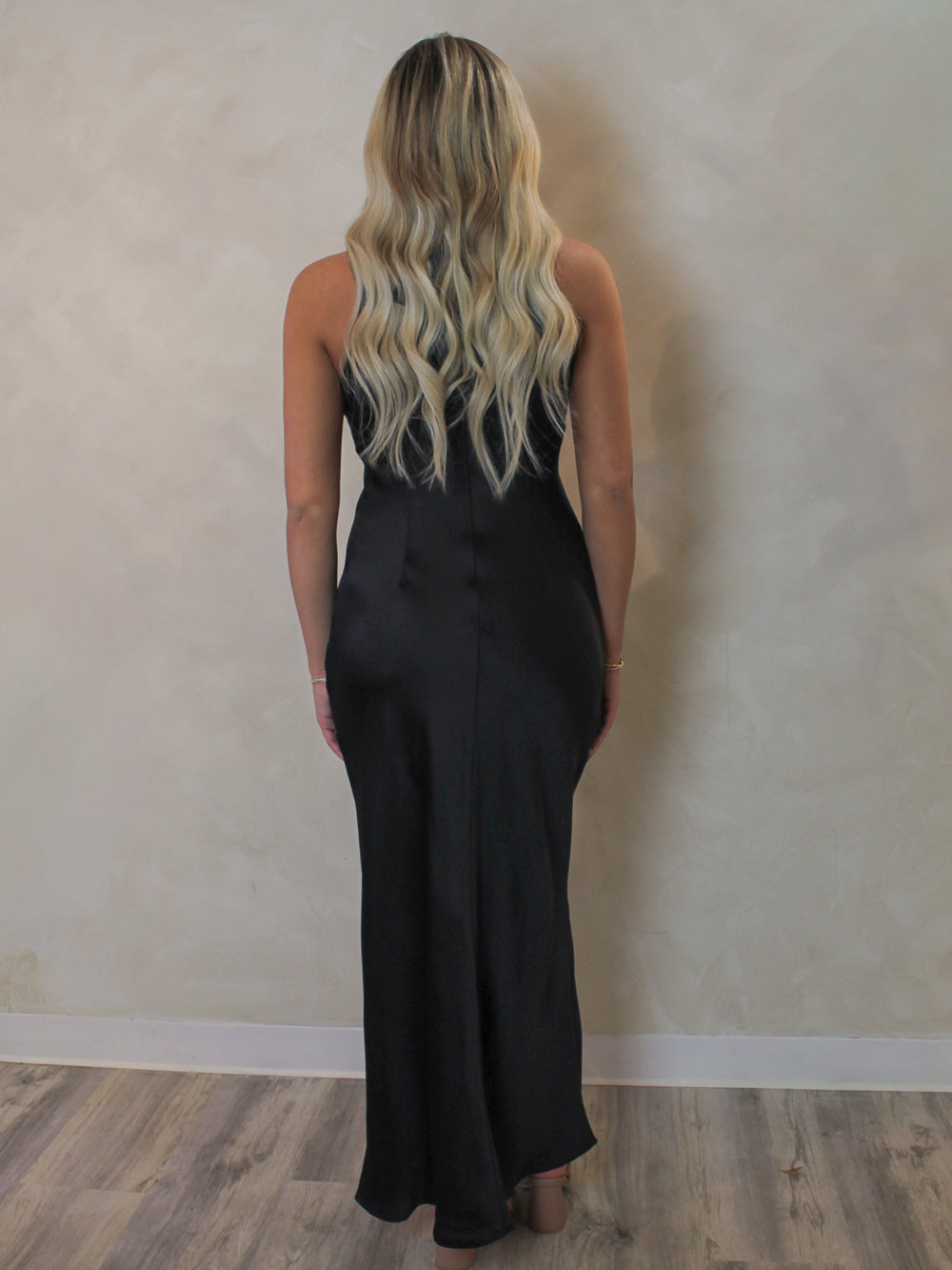 Model wearing a long black, satin slip dress