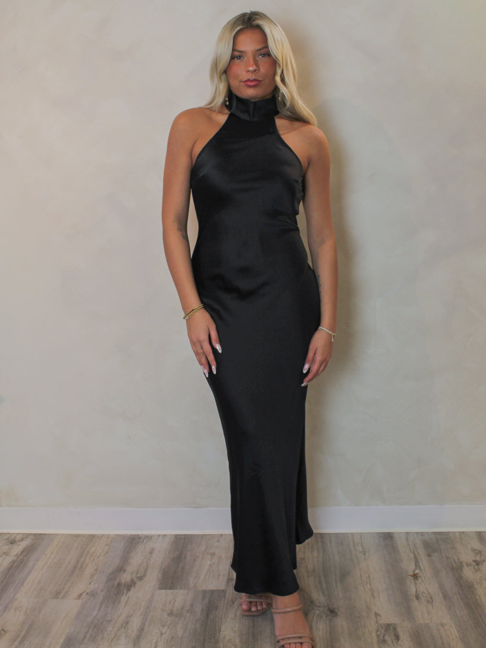 Model wearing a plain black halter neck slip dress from Steve Madden 