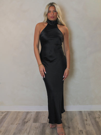 Model wearing a plain black halter neck slip dress from Steve Madden 