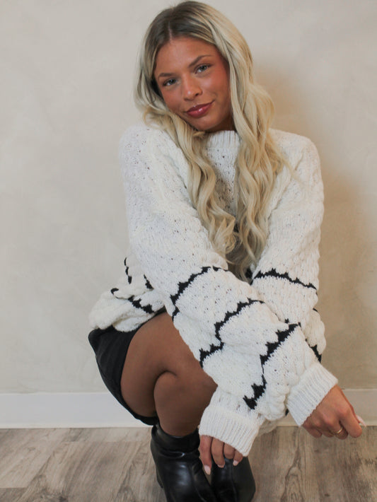 Model wearing a white oversized sweater with thin black stripes for fall