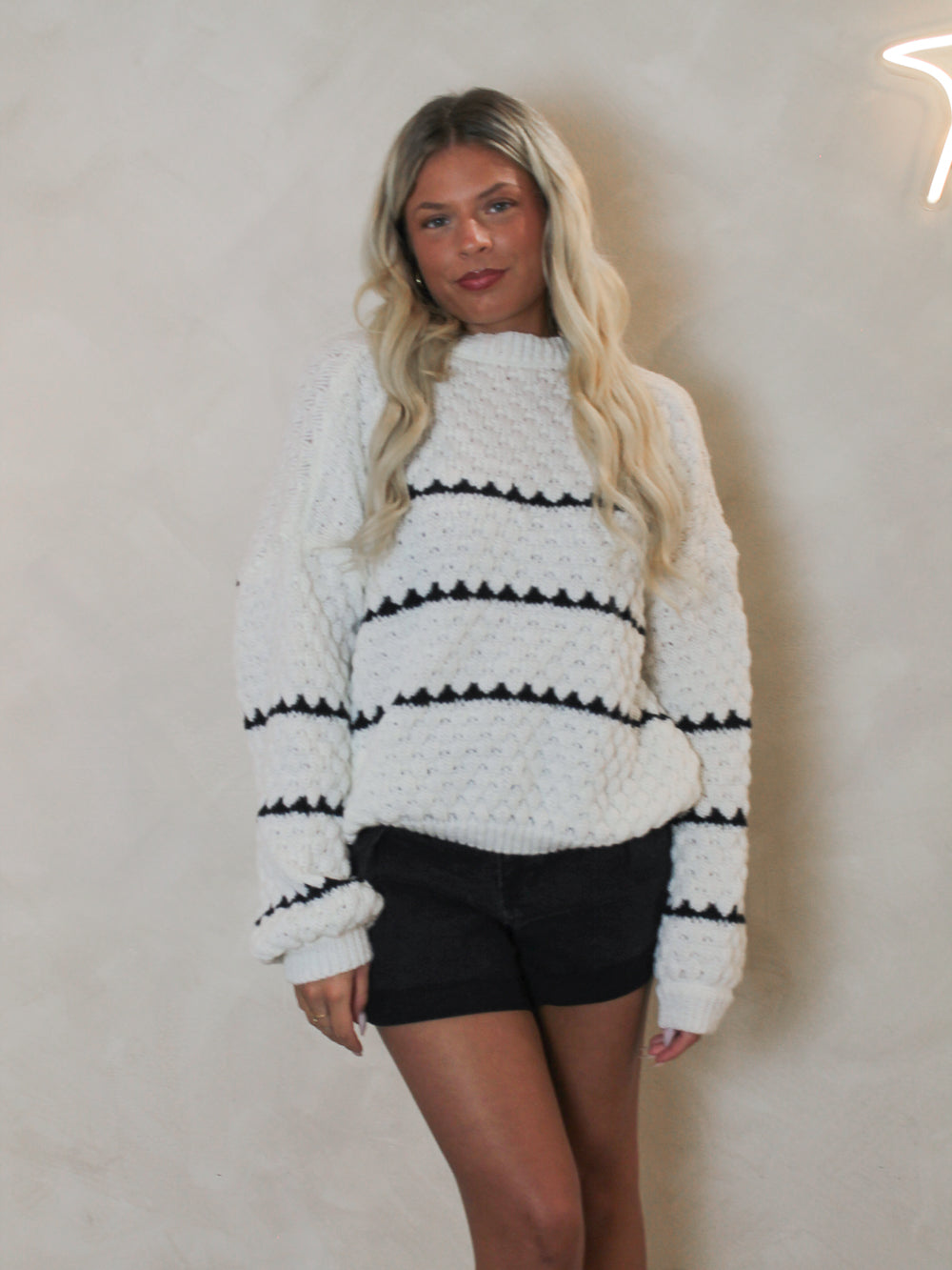 White knit, oversized sweater with black stripes. 