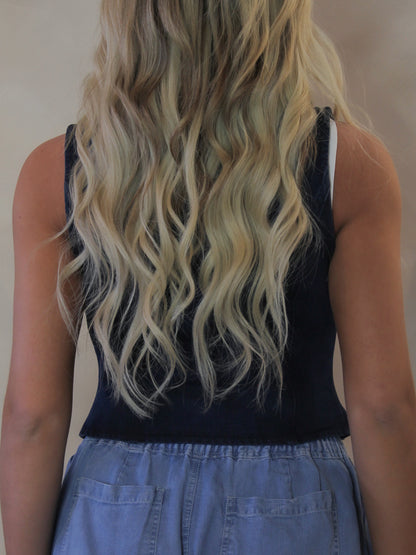 Back view of a model wearing a dark denim vest 