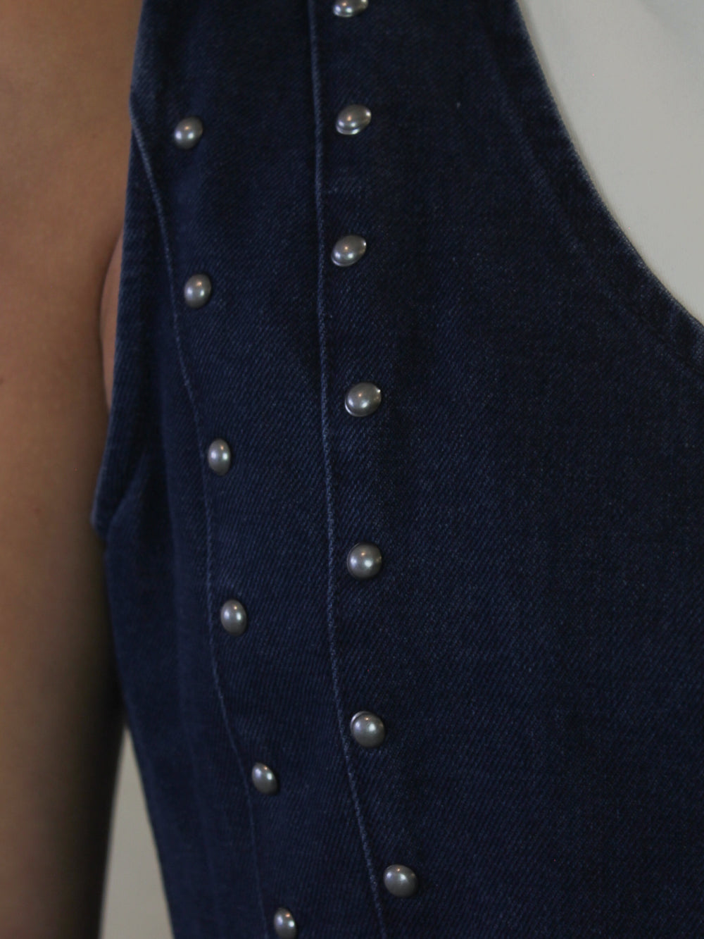 Dark denim vest with silver studded details 