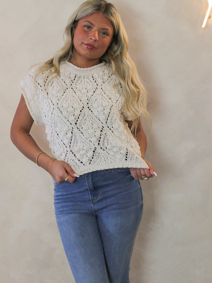 Model wearing a white open knit short sleeve sweater 