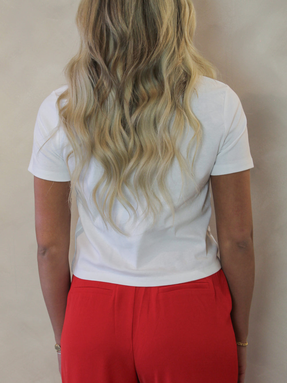 Model wearing a white tee with a slightly short hem 