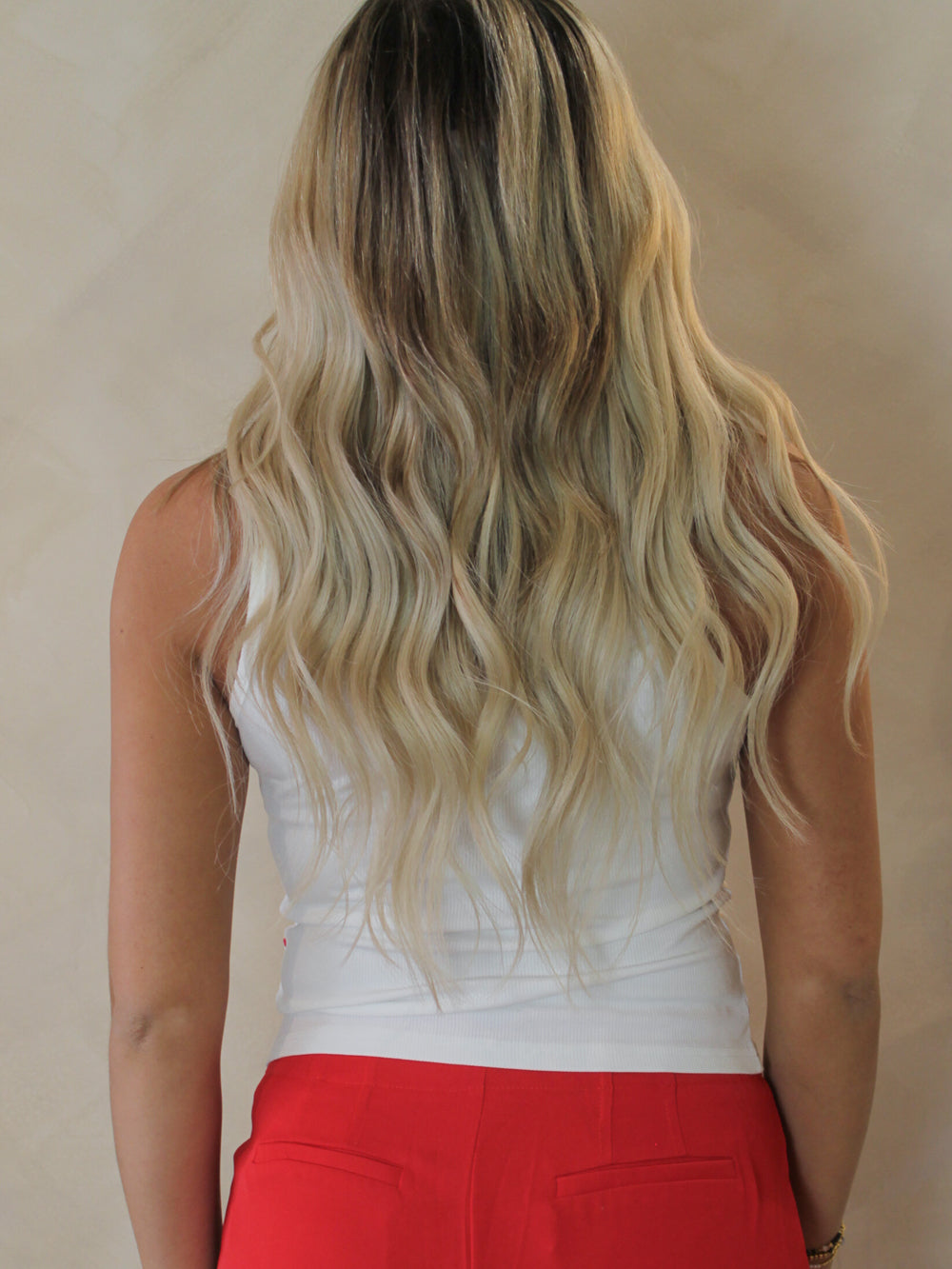 Model wearing a white ribbed racer back tank with red hearts on front 