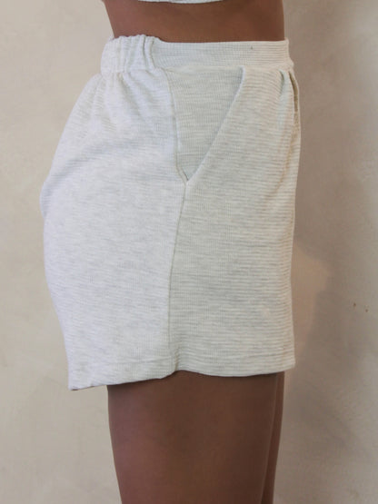 Model wearing light grey ribbed shorts 
