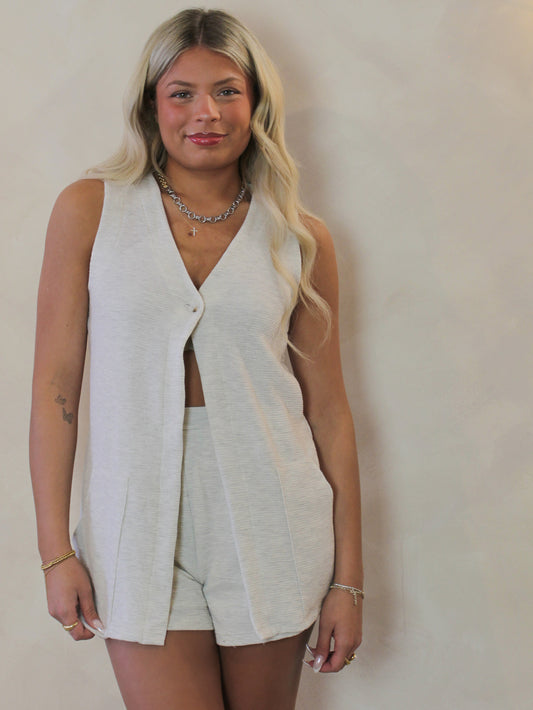 Model wearing an open front vest with matching shorts 