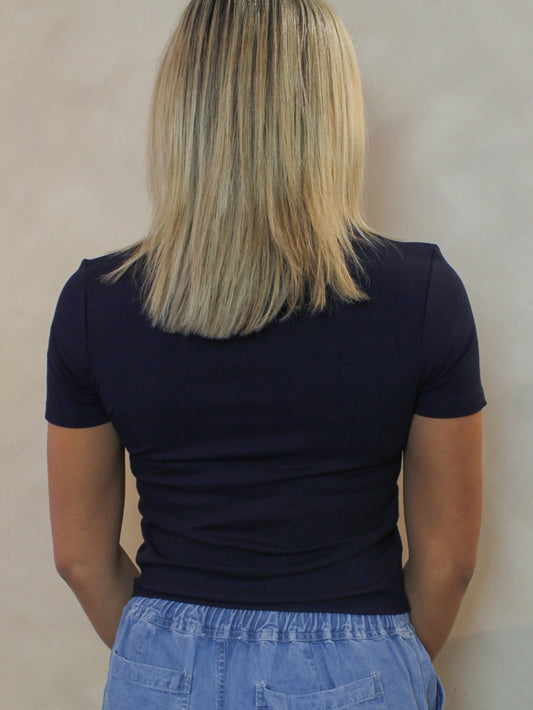 Woman wearing a navy blue ribbed tee shirt.