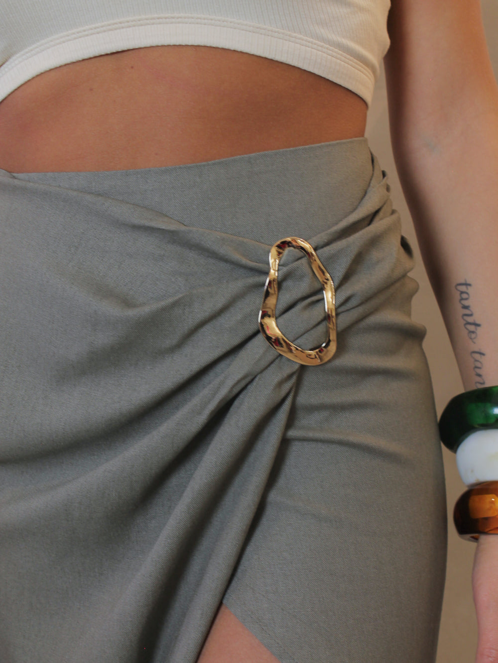 gold ring detail on an olive linen skirt