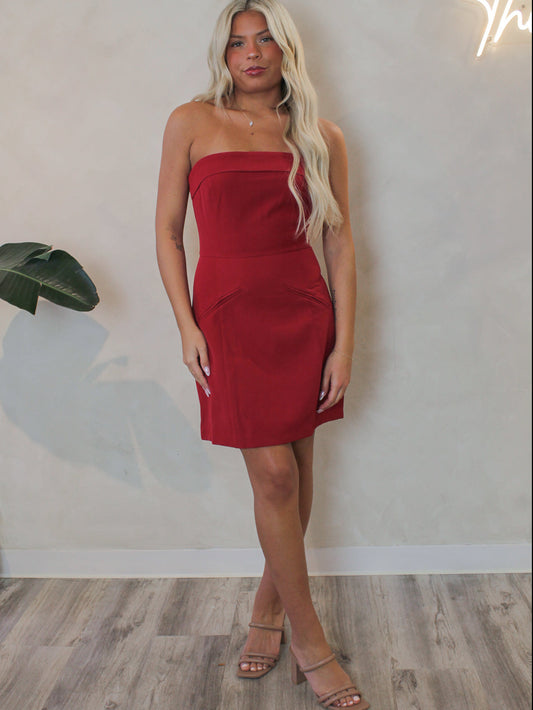 Model wearing a red strapless dress for the holidays 