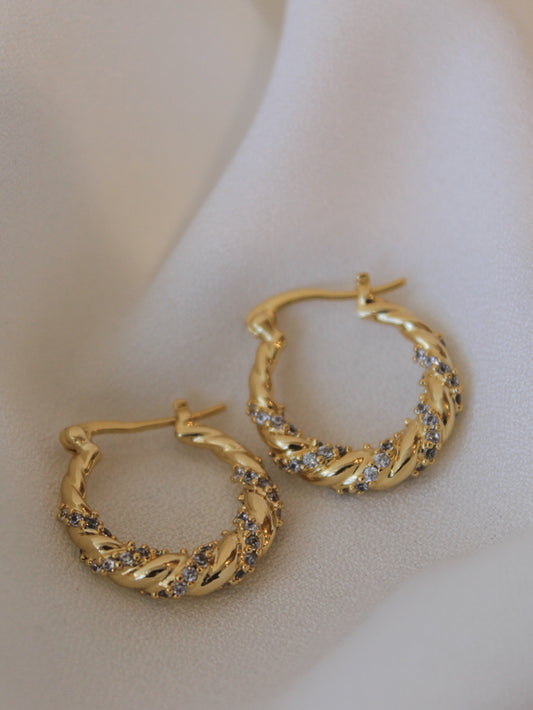 A pair of gold twisted hoops with cz stone details 