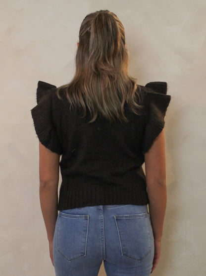 Back view of a dark brown ribbed sweater with a mock neck and dramatic ruffle cap sleeves.