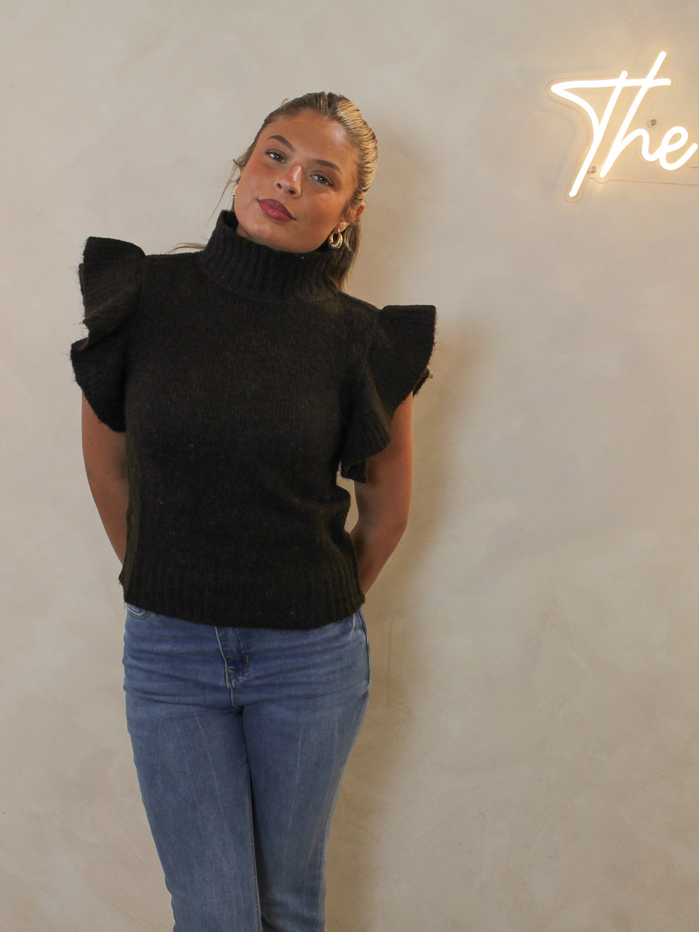 Chocolate brown ribbed sweater with a mock neck and dramatic ruffle cap sleeves.