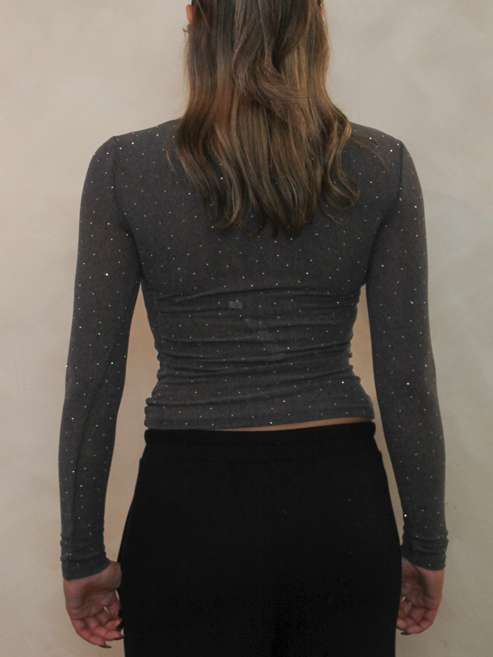 Back view of a long sleeve charcoal grey top with all over rhinestone details.