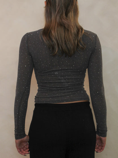 Back view of a long sleeve charcoal grey top with all over rhinestone details.