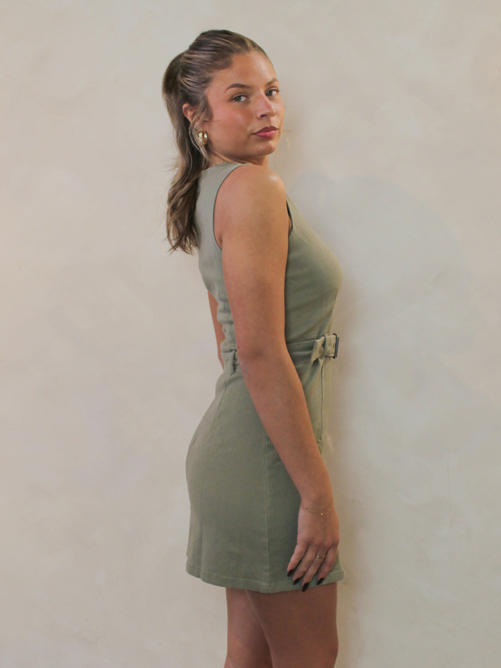 Side view of an olive green denim mini dress.