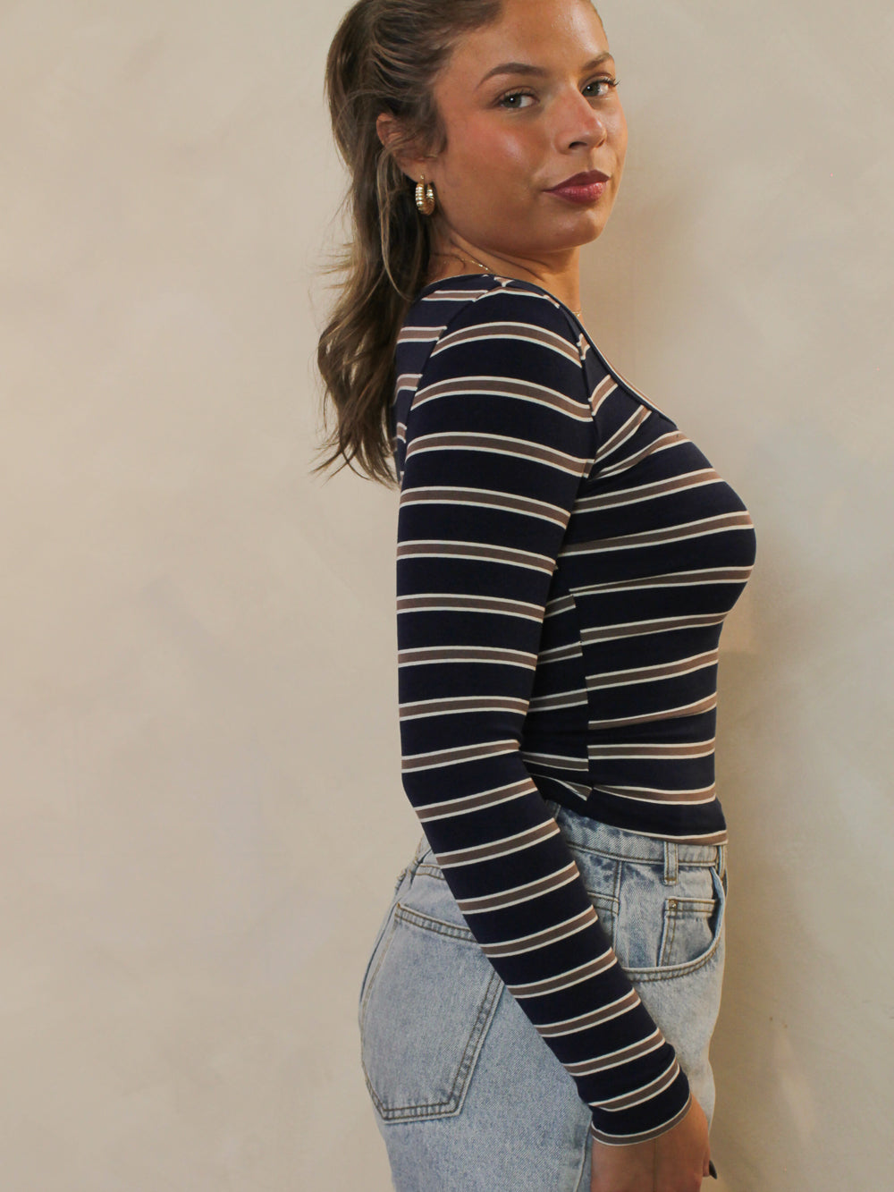 Side view of navy and chocolate striped scoop neck top 