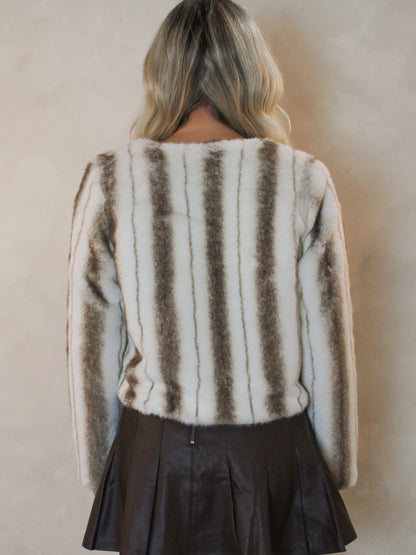 Back view of a cream faux fur jacket with brown striped detail