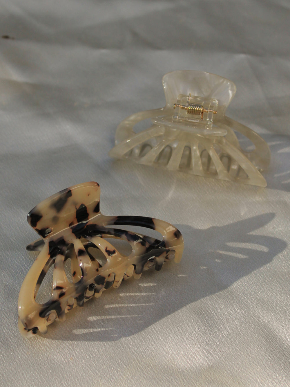 Two hair clips, one tortoiseshell and one cream