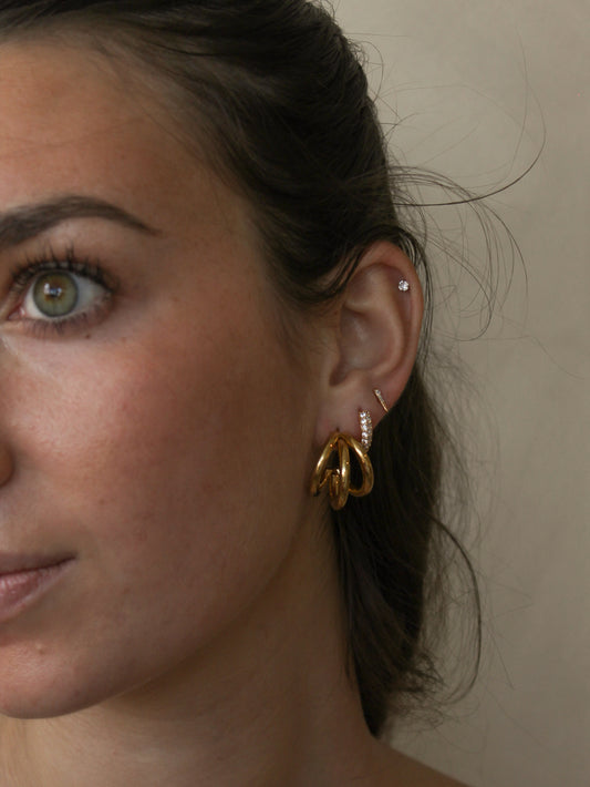 Close-up of a woman wearing gold hoop earring stack