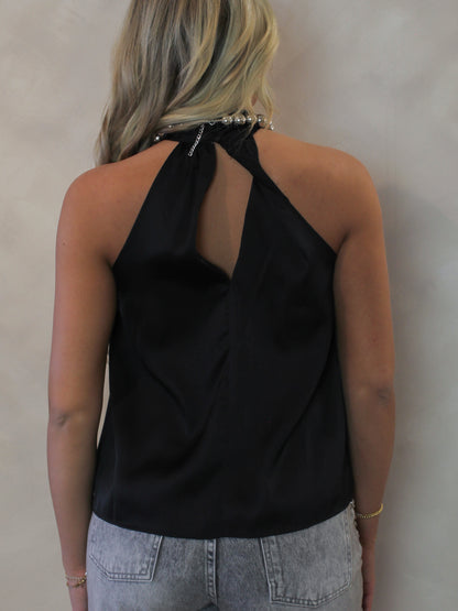 Back view of a woman wearing a black halter top with a key hole design