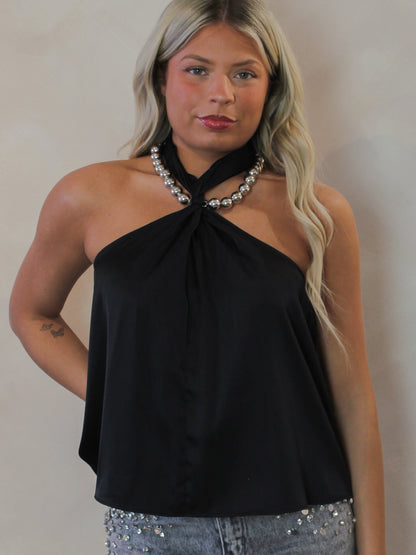 Model wearing a black satin halter top with a silver necklace