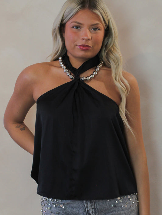 Model wearing a black satin halter top with a silver necklace
