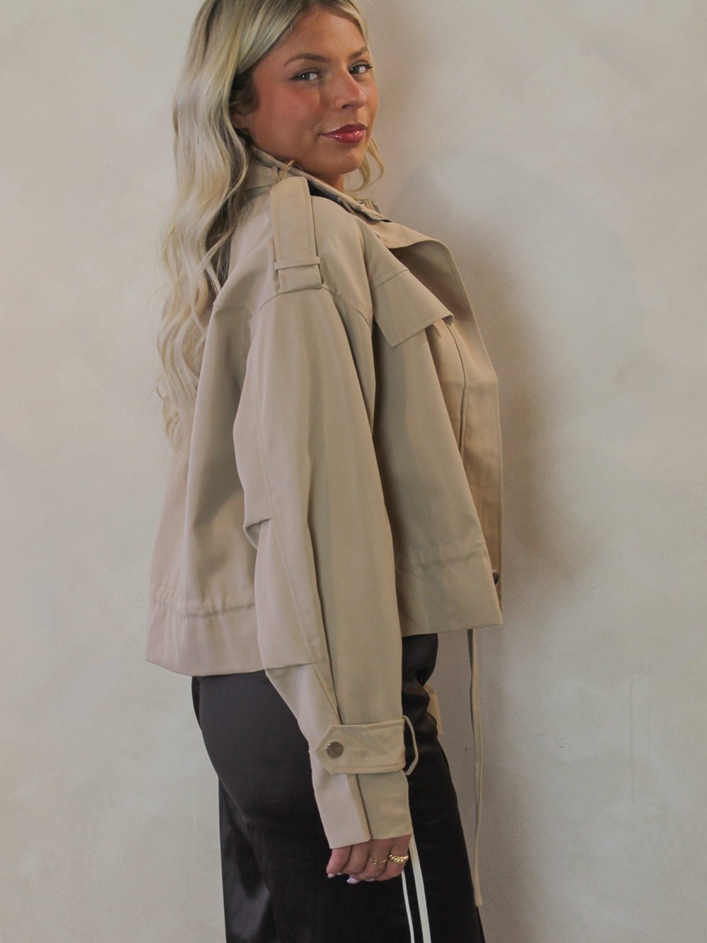 Side view of a cropped trench coat on a model 