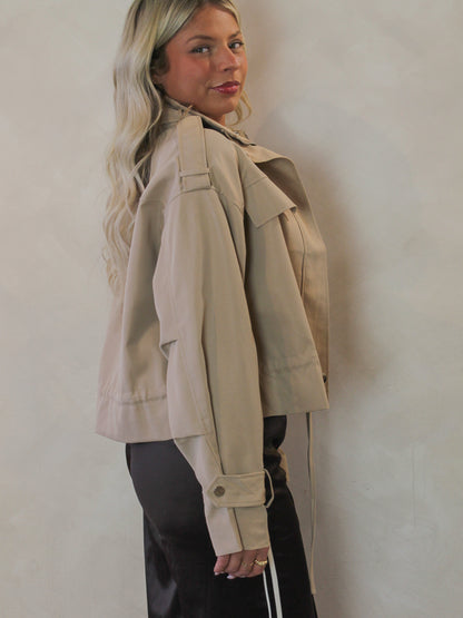 Side view of a cropped trench coat on a model 