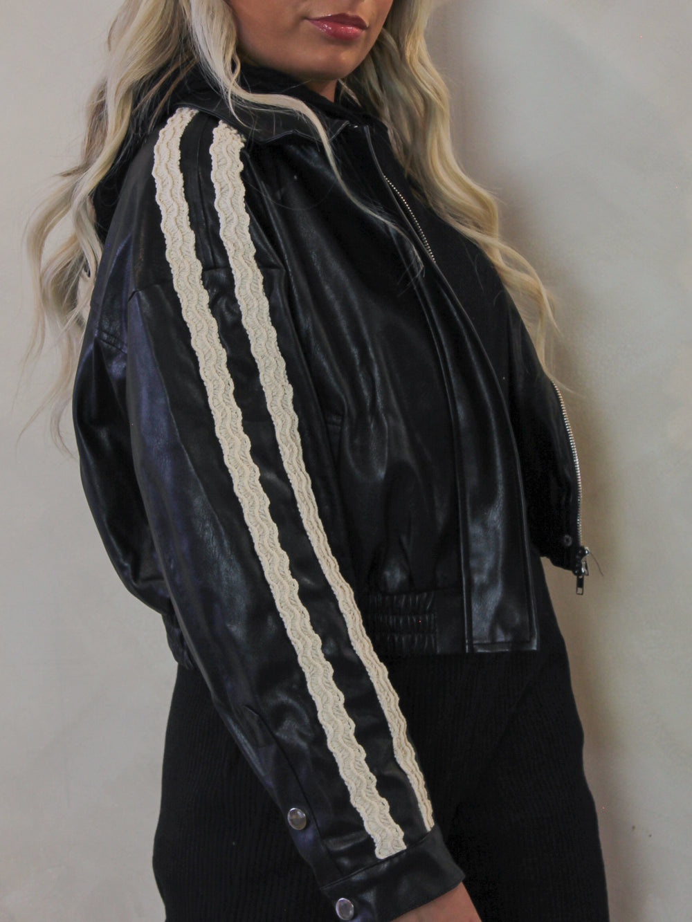 Black, faux leather jacket with white lace trim accents 
