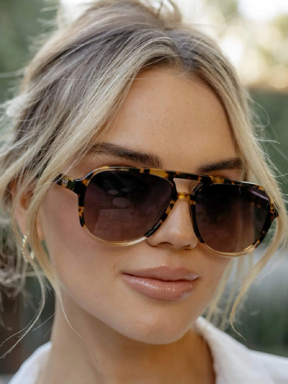 Woman wearing tortoise shell aviator sunglasses