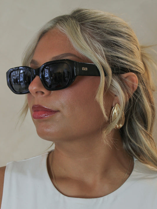 woman wearing black, chic, rectangular sunglasses with goldj ewelry