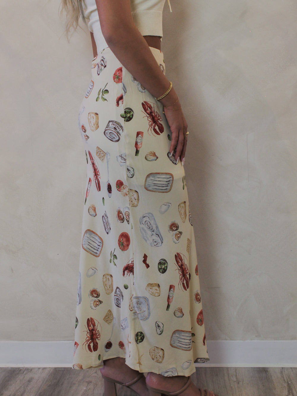 Side view of a Model wearing a neutral coastal pattern skirt 