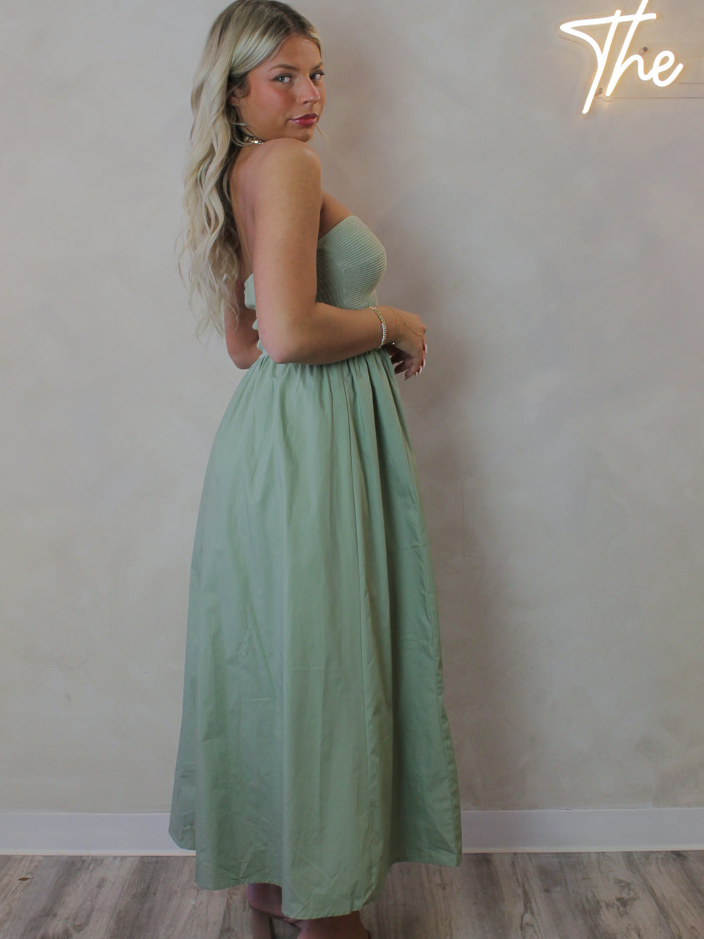 Model wearing a sage green strapless, spring dress