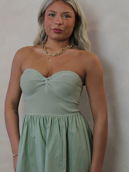 Model wearing a strapless sage green dress
