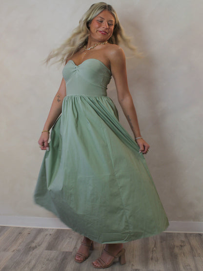 Model wearing a sage green strapless dress for spring 