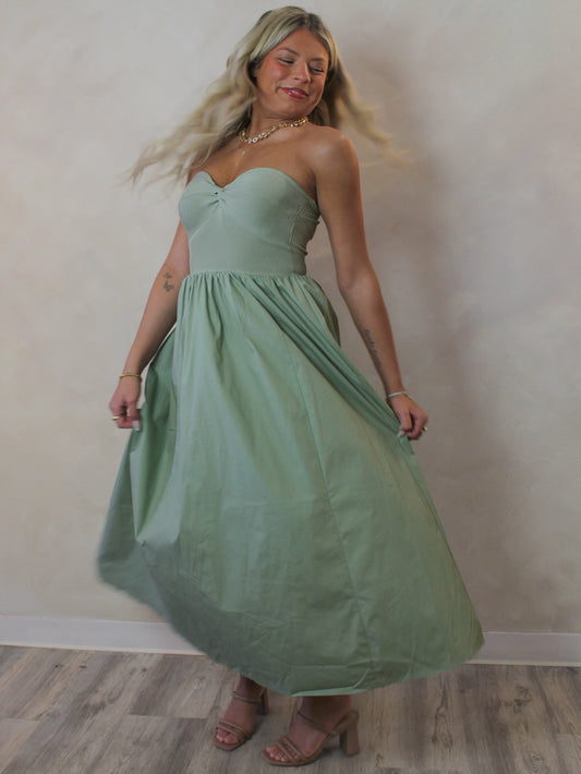 Model wearing a sage green strapless dress for spring 