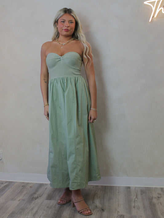 Model wearing a strapless sage green midi dress for spring 